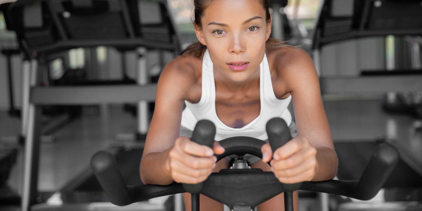 Pessoa pedalando em bicicleta ergométrica em casa
